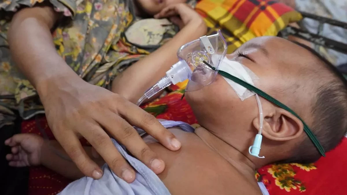 অসুস্থ শিশু সন্তানের বুকে হাত রেখে শুয়ে আছেন মা।